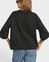 Person wearing a black oversized sweater and blue jeans on a white background