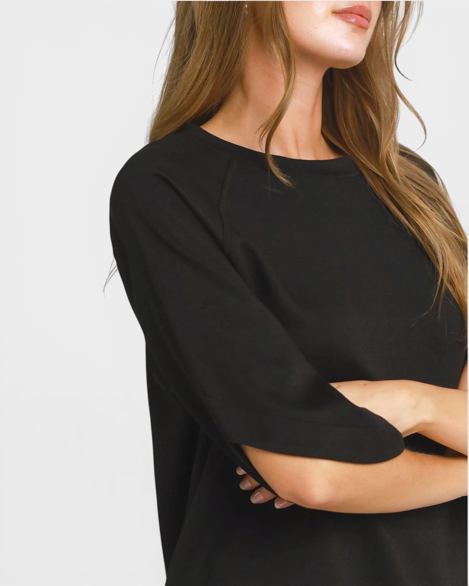 Person wearing a black sweater on a plain background