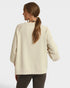 Woman wearing a beige oversized sweater with a plain background