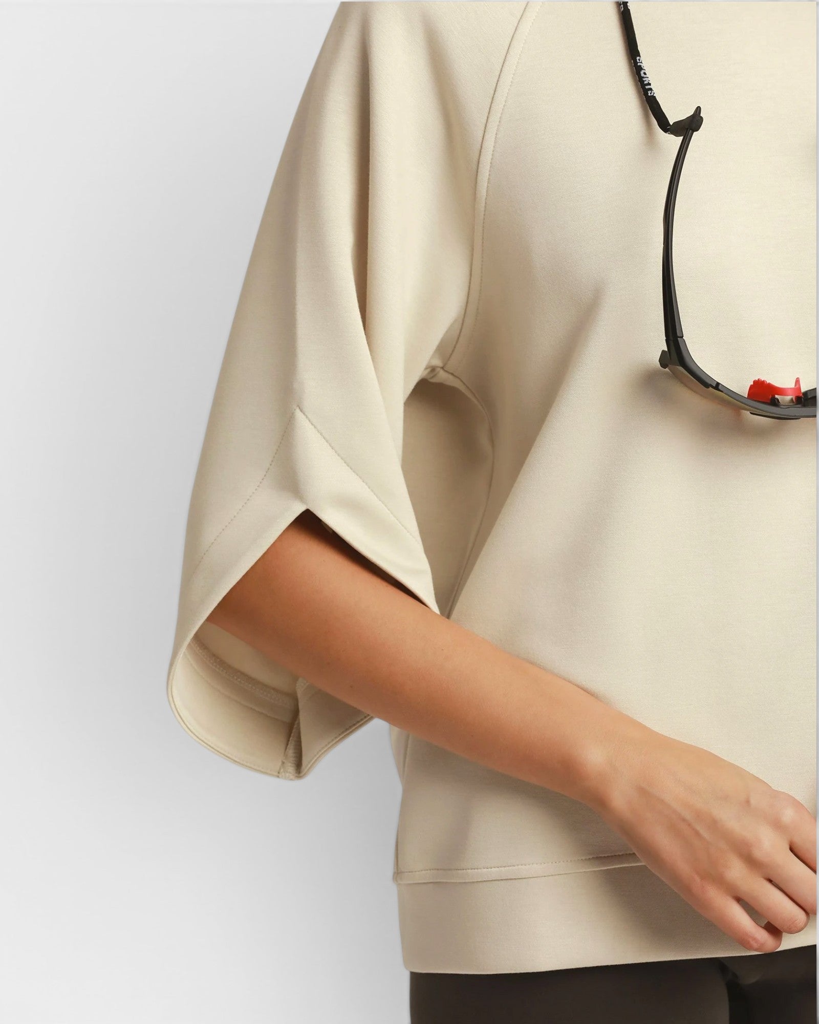 Beige blouse with a black strap over a white background