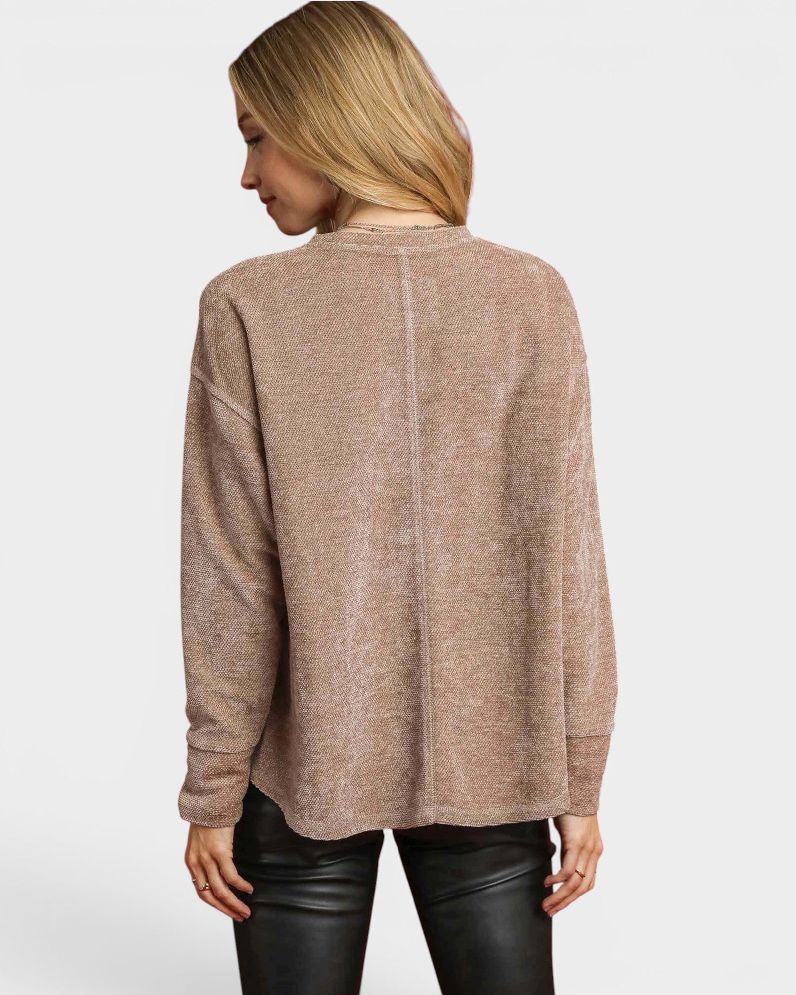 Woman wearing a beige sweater on a white background