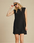Woman wearing a black sleeveless dress and sunglasses on a beige background