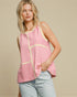 Woman wearing a pink and white striped sleeveless top with a beige background