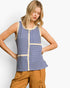 A woman modeling a sleeveless knit top with blue and cream vertical stripes and patchwork panel details, paired with tan cargo pants, against a light gray studio background.