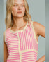 Woman wearing a pink and beige striped sleeveless top against a gray background