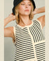 Woman wearing a black and white striped sleeveless top with a neutral background