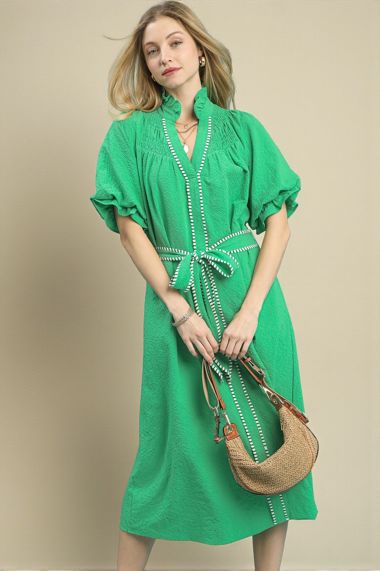 Woman wearing a green dress with a beige background