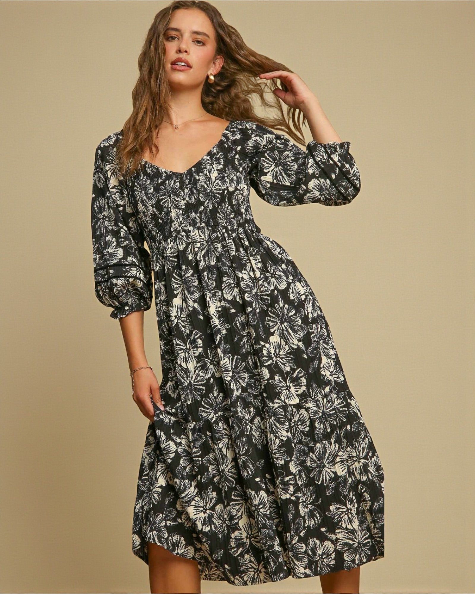 Woman wearing a black floral dress against a beige background