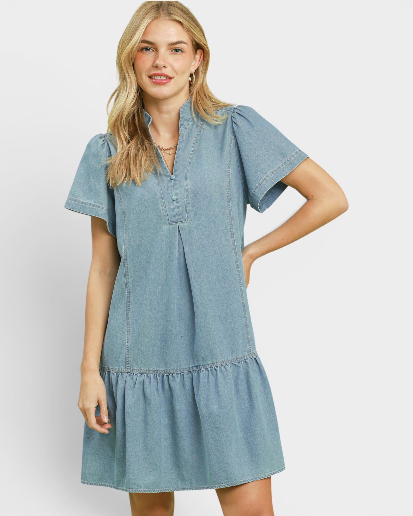 Woman wearing a denim dress on a plain background