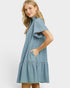 Woman wearing a light blue denim dress on a white background