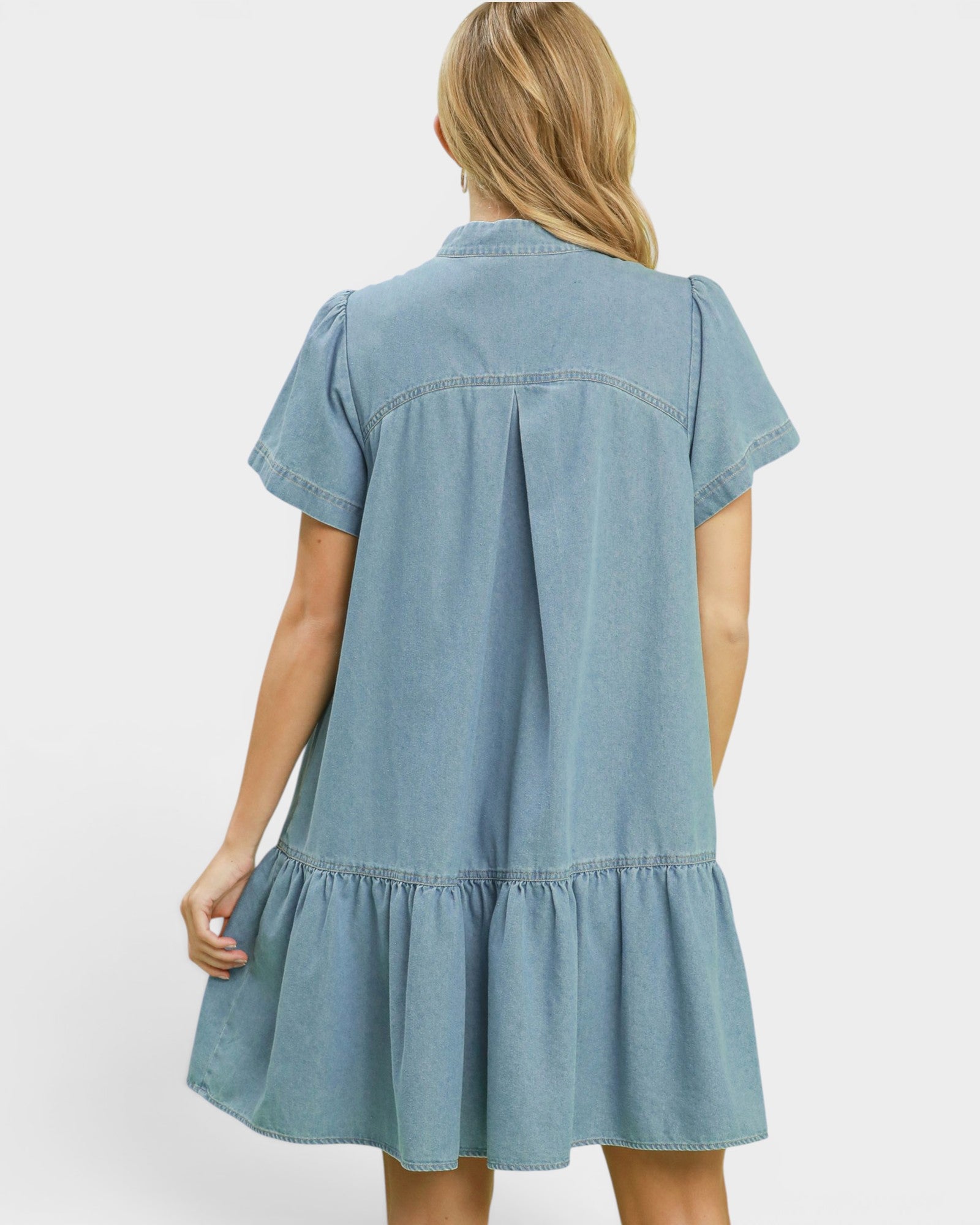 Light blue denim dress worn by a person on a white background