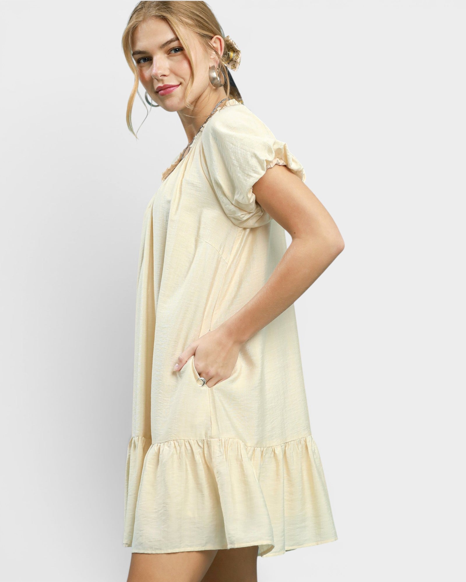 Woman wearing a light yellow dress on a white background