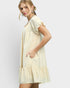 Woman wearing a light yellow dress on a white background