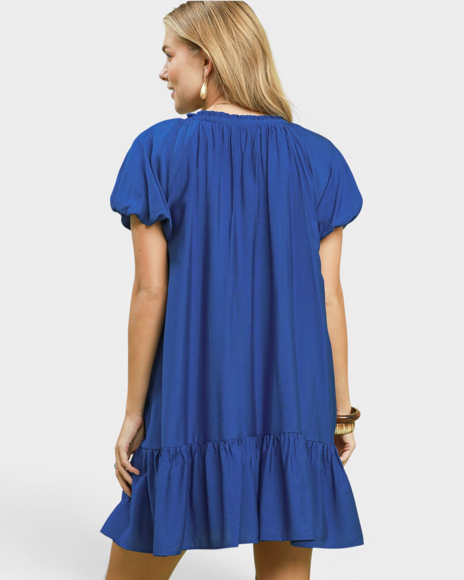 Woman wearing a blue dress with a plain background
