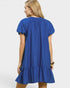 Woman wearing a blue dress with a plain background