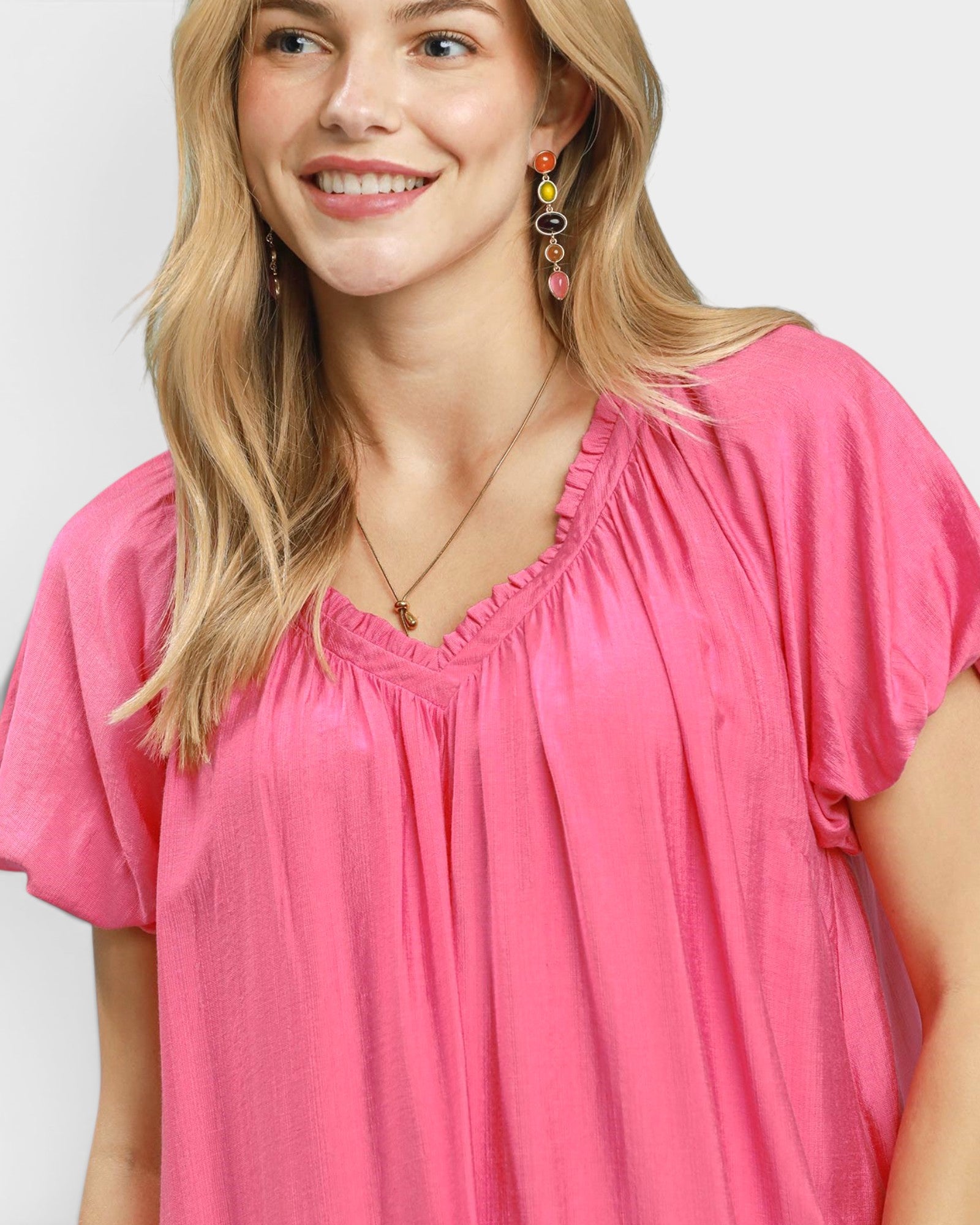 Woman wearing a pink blouse with a plain background