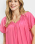 Woman wearing a pink blouse with a plain background