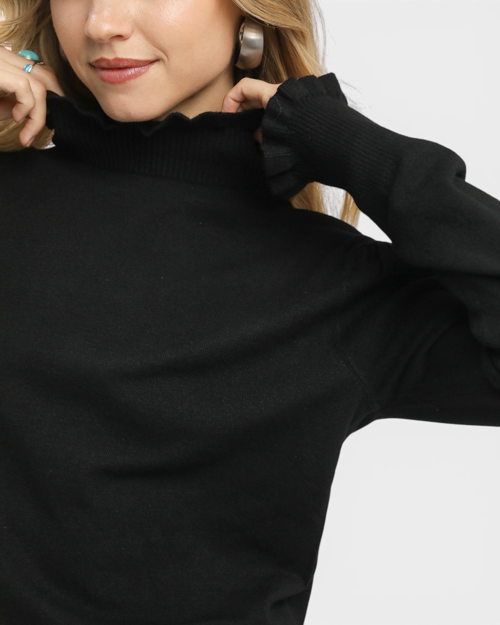 Person wearing a black turtleneck sweater on a white background