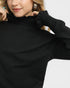 Person wearing a black turtleneck sweater on a white background