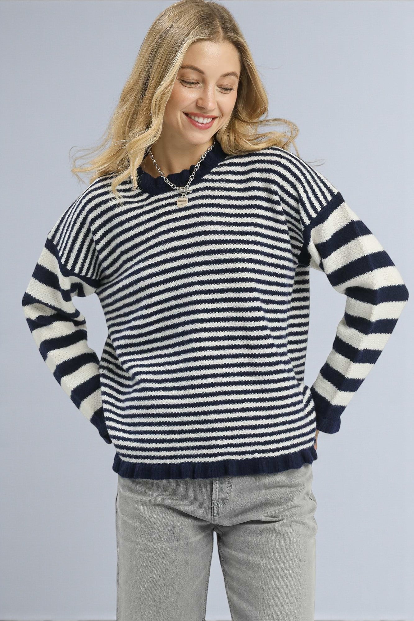 Woman wearing a black and white striped sweater against a plain background