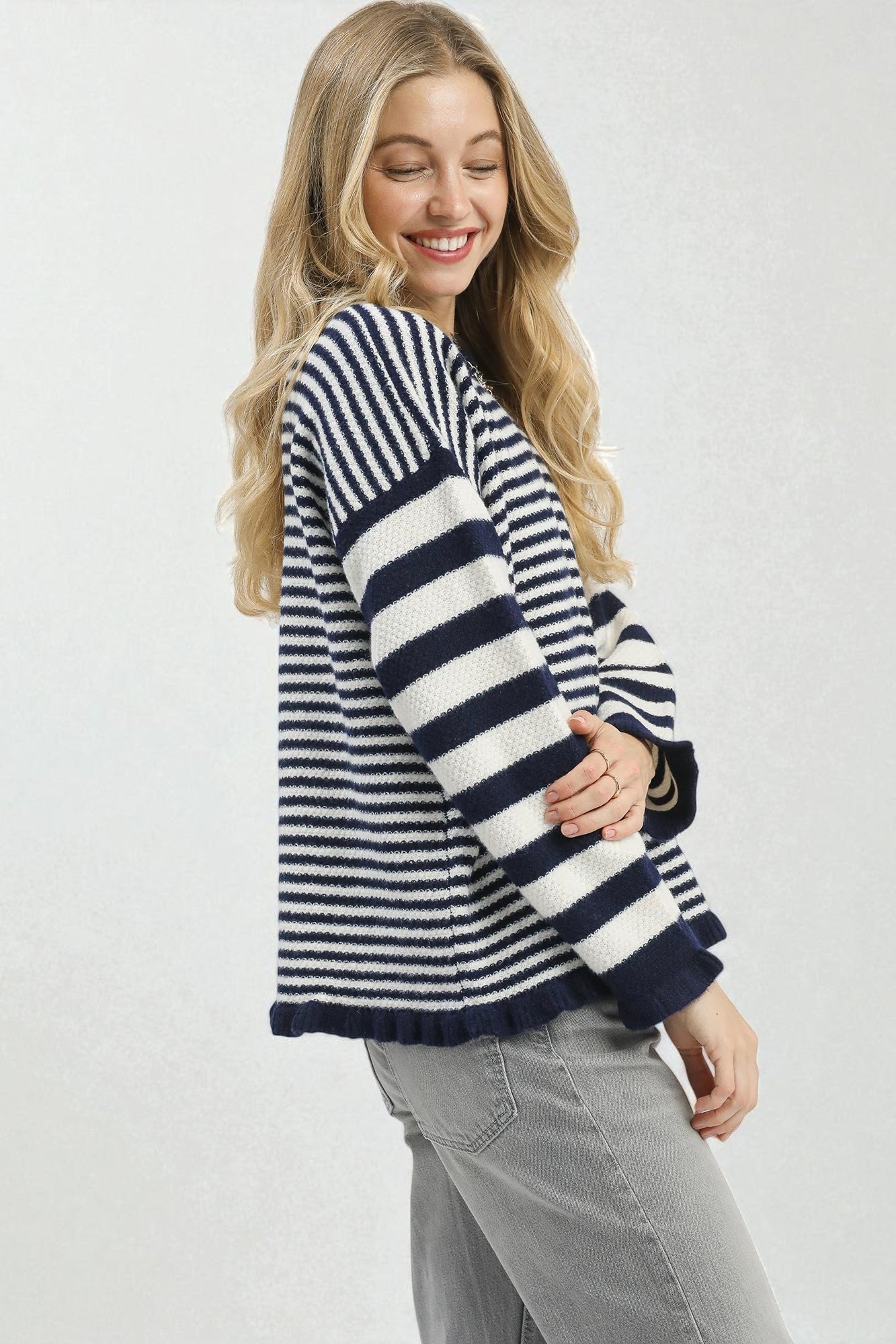 Woman wearing a navy and white striped sweater on a plain background