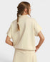 Woman wearing a beige outfit with a plain background