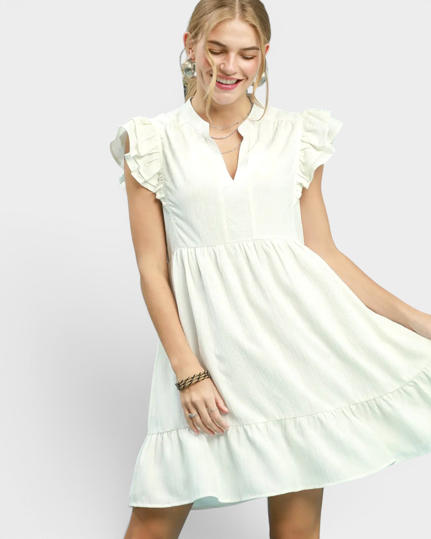 Woman wearing a light green dress against a plain background