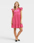 Woman wearing a pink dress with ruffled sleeves on a white background