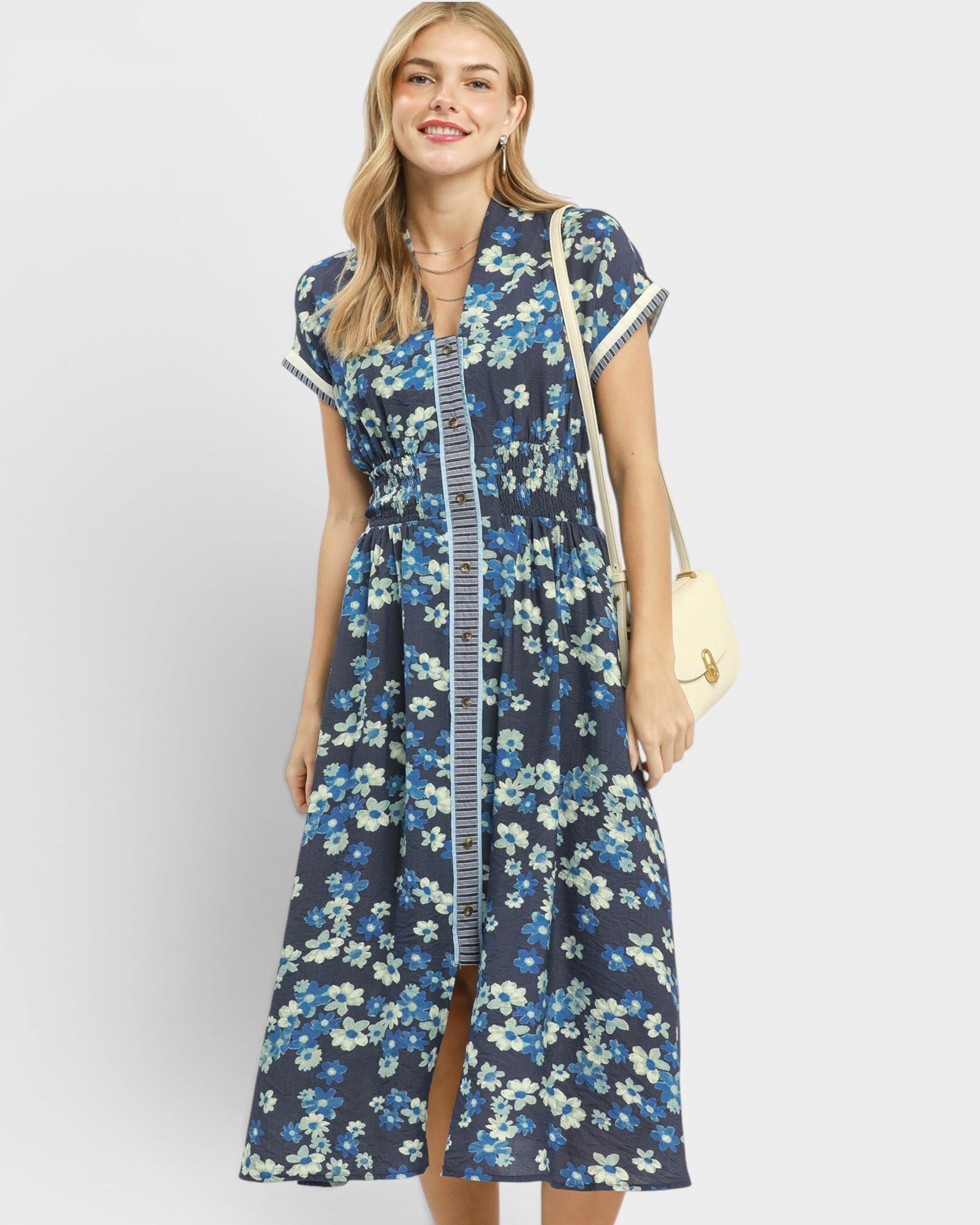 Woman wearing a blue floral dress with a white background
