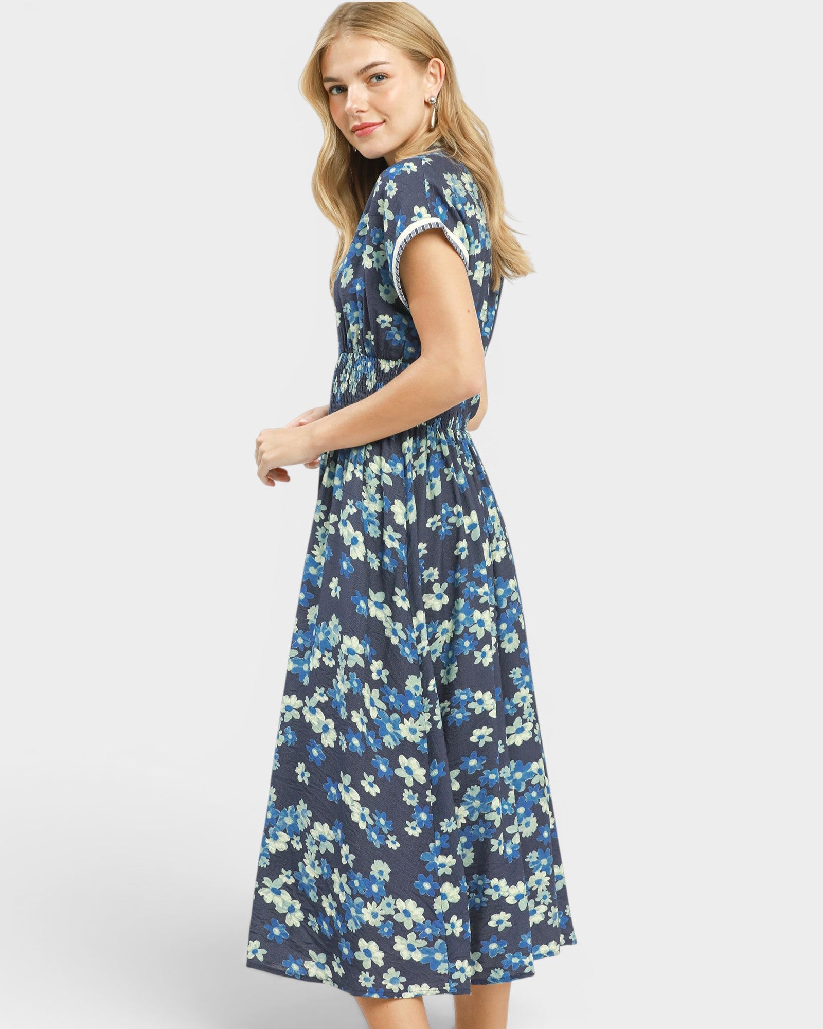 Woman wearing a blue floral dress on a white background