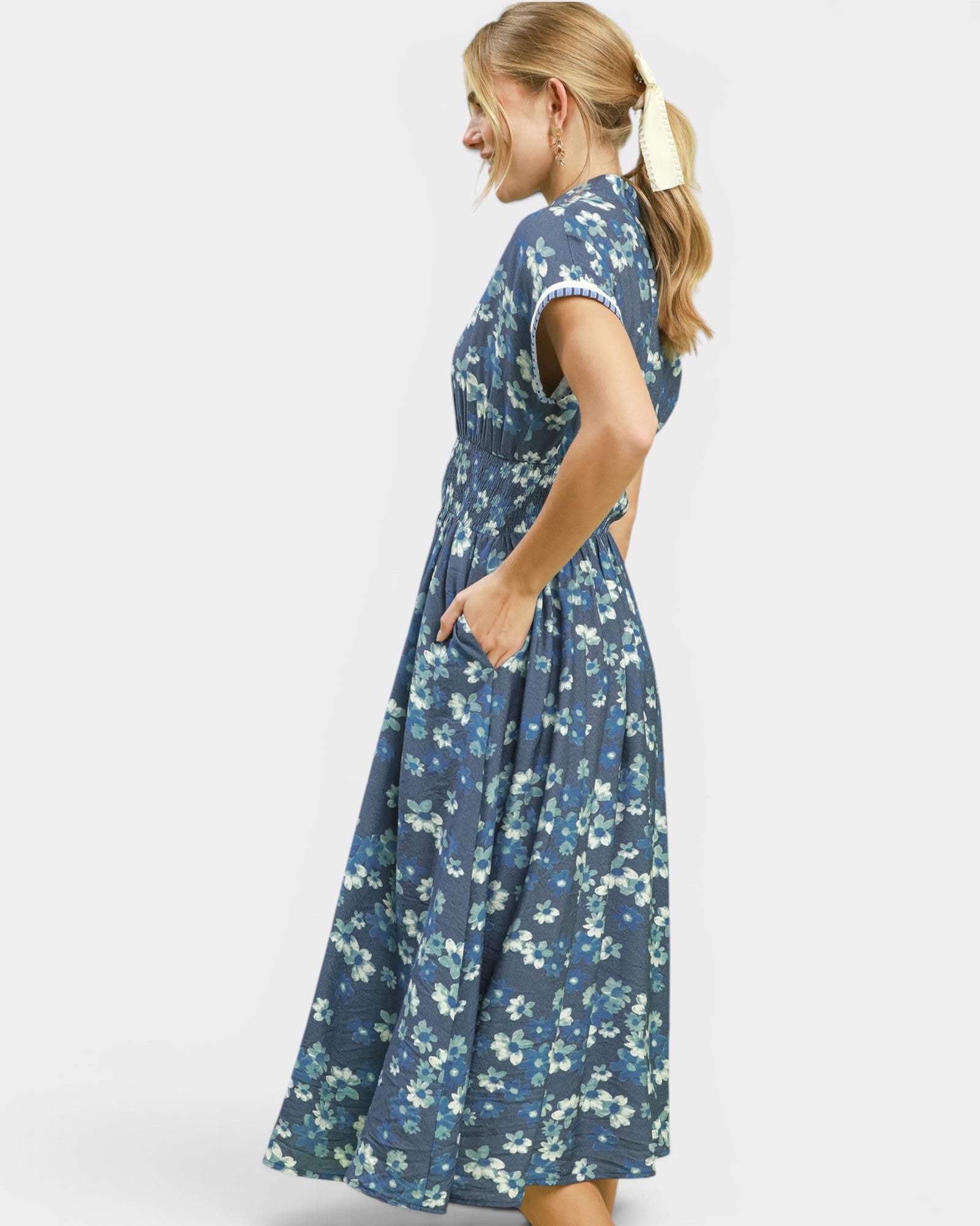 Woman wearing a blue floral dress on a white background