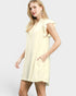 Woman wearing a light yellow dress with ruffled sleeves on a white background