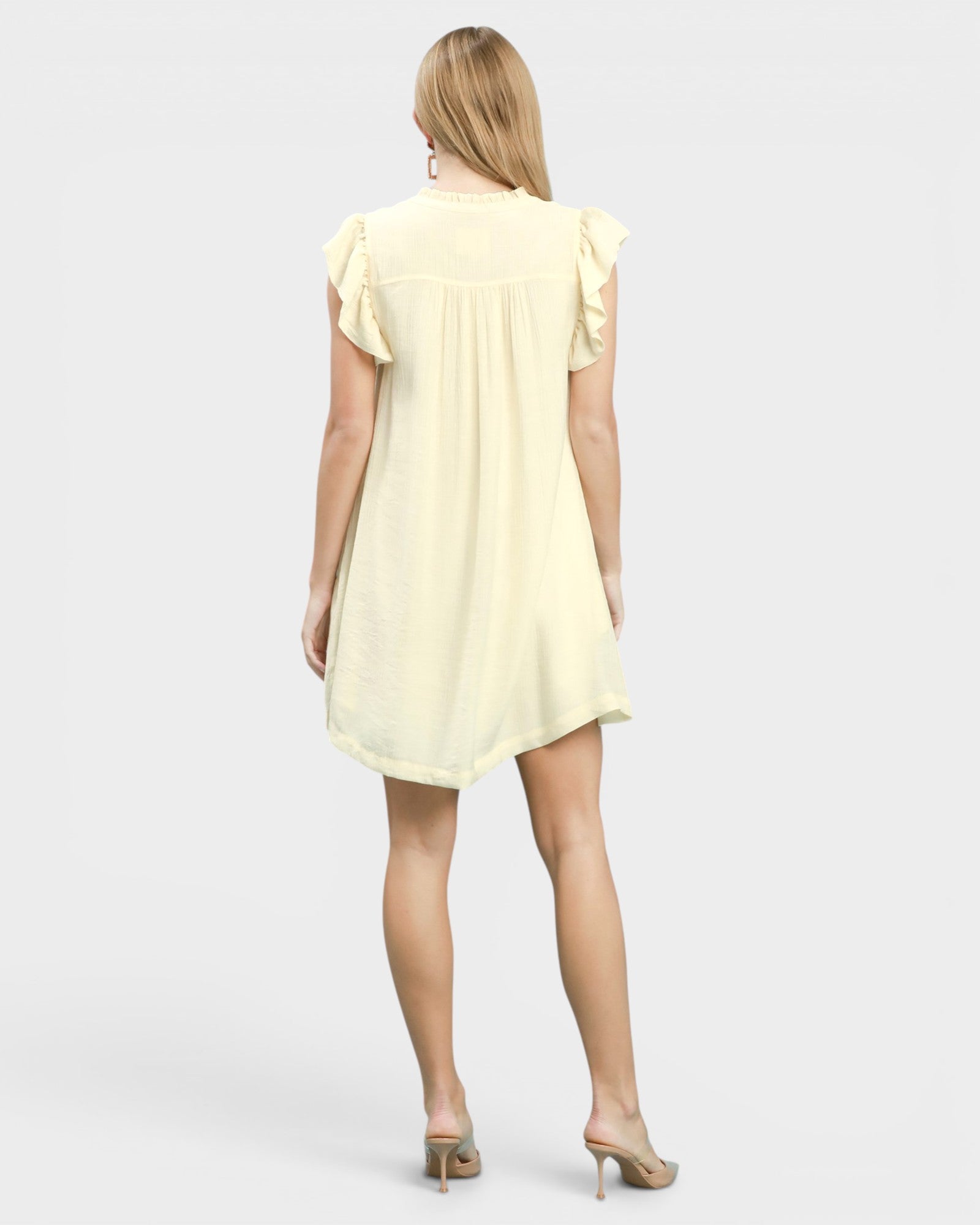Woman wearing a light yellow dress on a white background