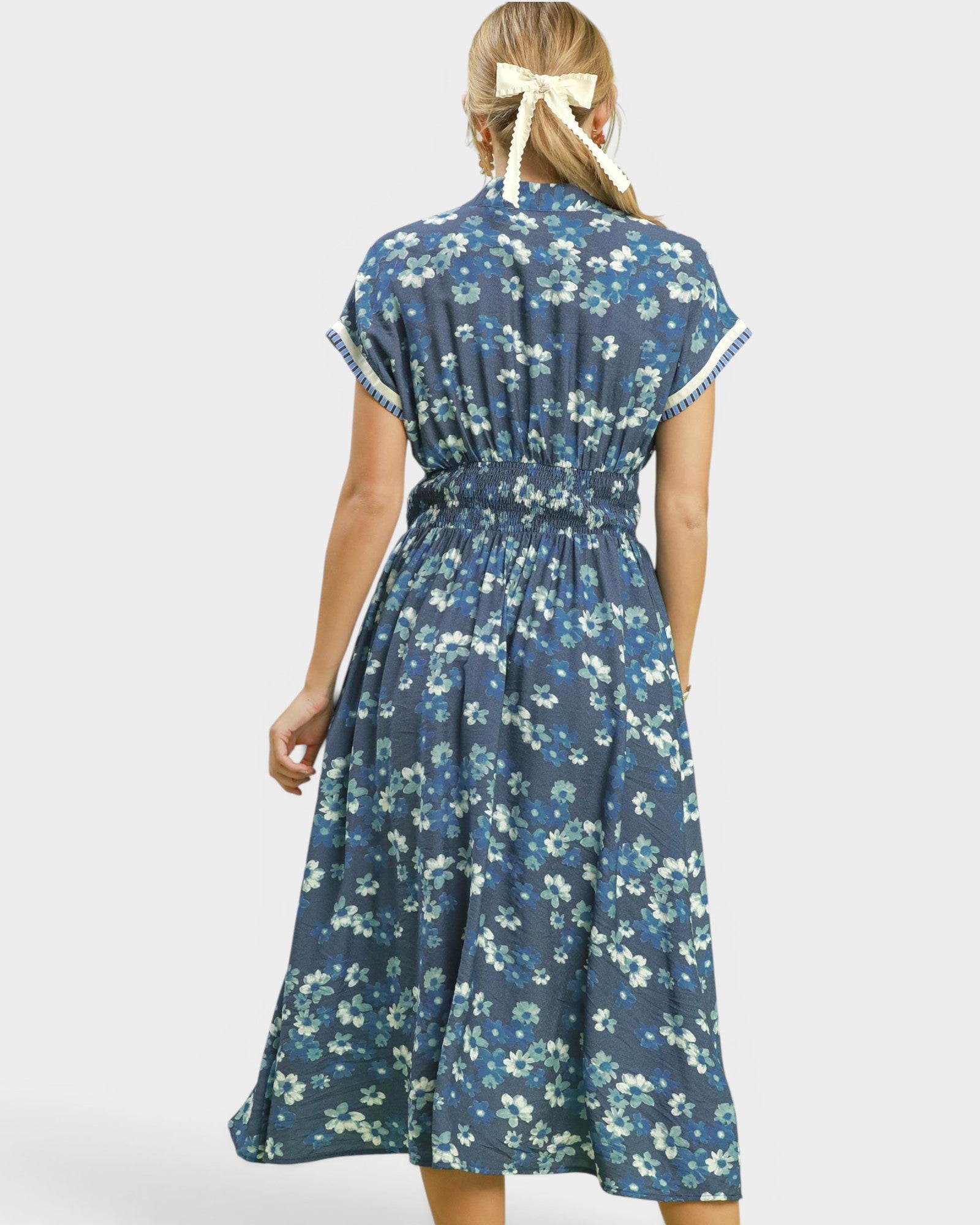 Woman wearing a blue floral dress on a white background