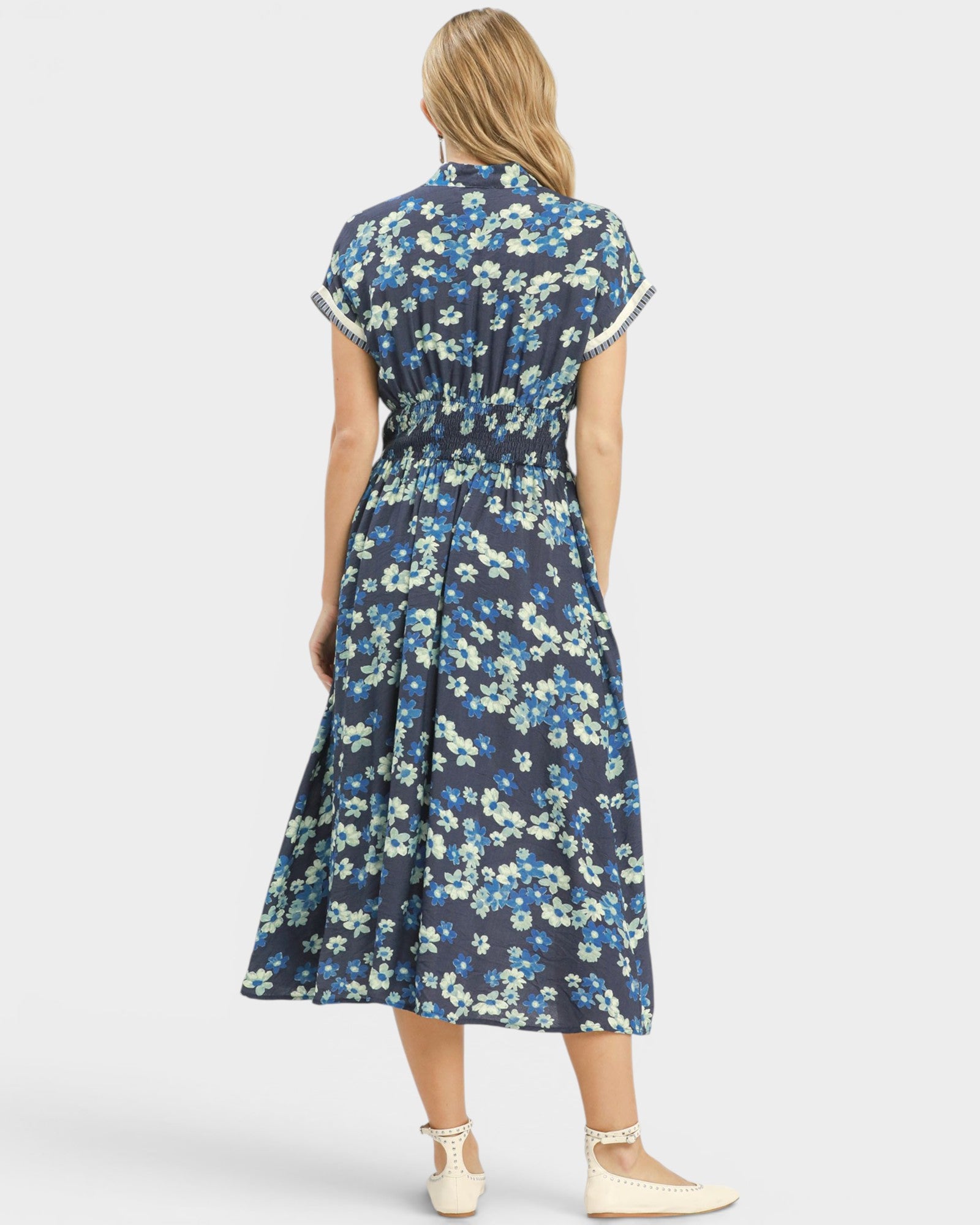 Woman wearing a blue floral dress on a white background