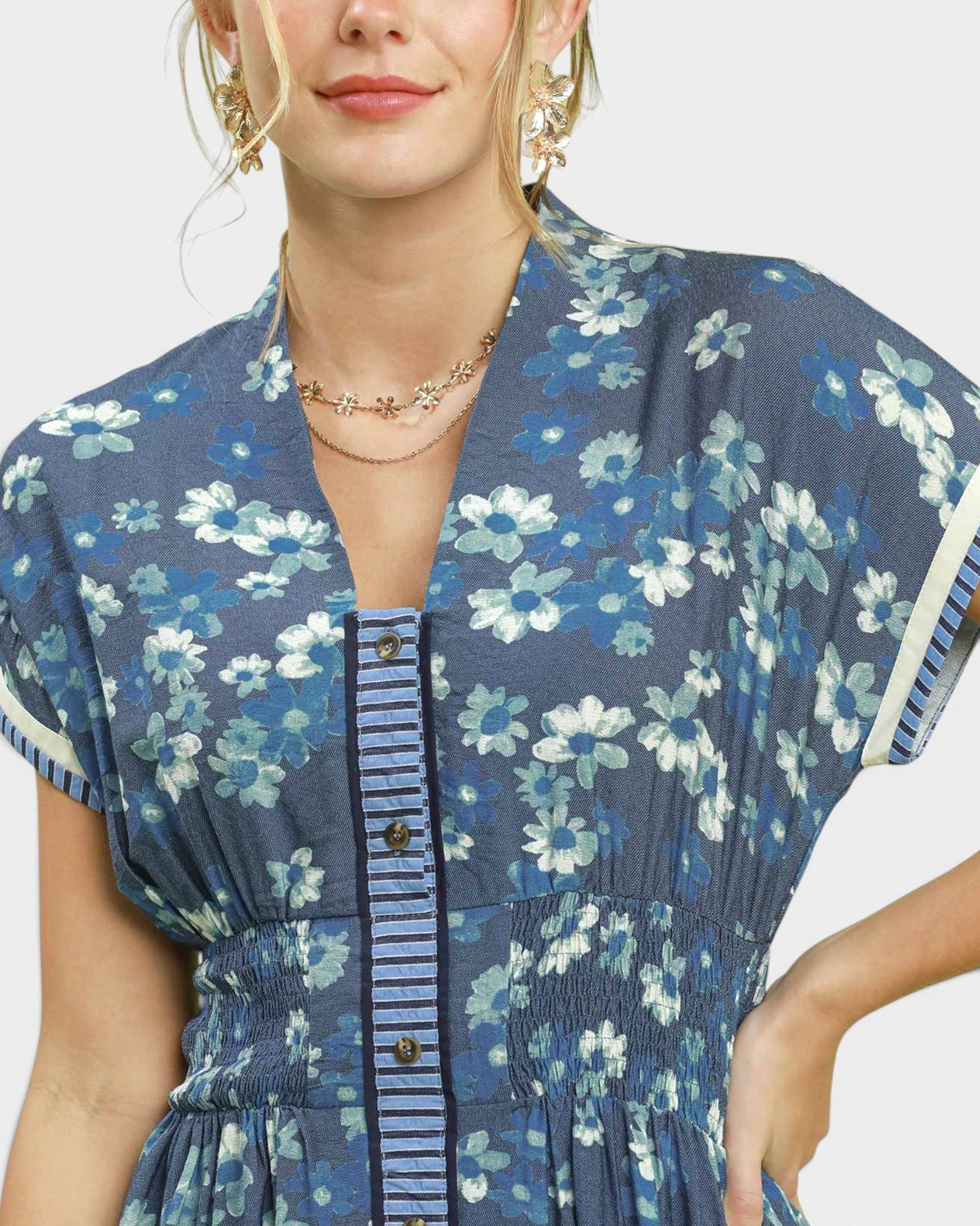 Woman wearing a blue floral dress with a white background