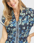 Woman wearing a blue floral dress with a plain background