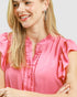 Woman wearing a pink blouse with a plain background