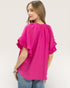 Woman wearing a bright pink blouse with ruffled sleeves on a white background