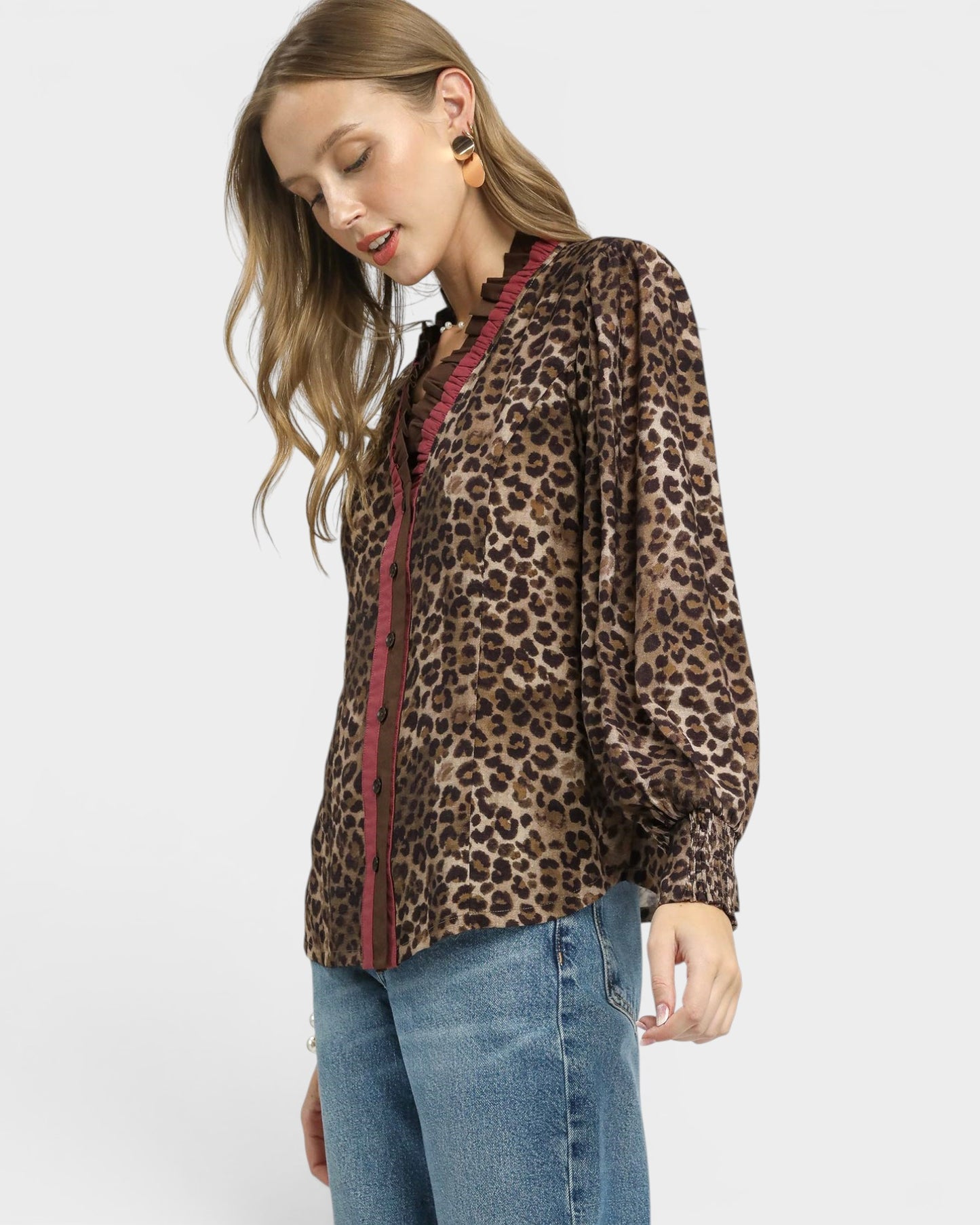 Woman wearing a leopard print jacket with a red zipper on a white background