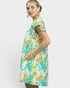 Woman wearing a colorful floral dress on a white background