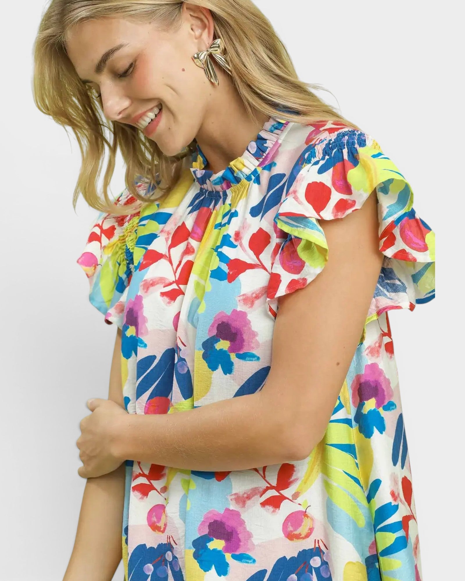 Woman wearing a colorful floral dress against a white background