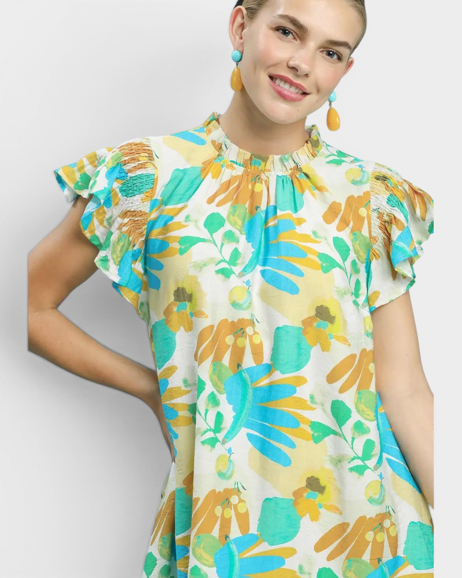 Woman wearing a colorful floral dress against a white background