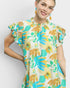 Woman wearing a colorful floral dress against a white background