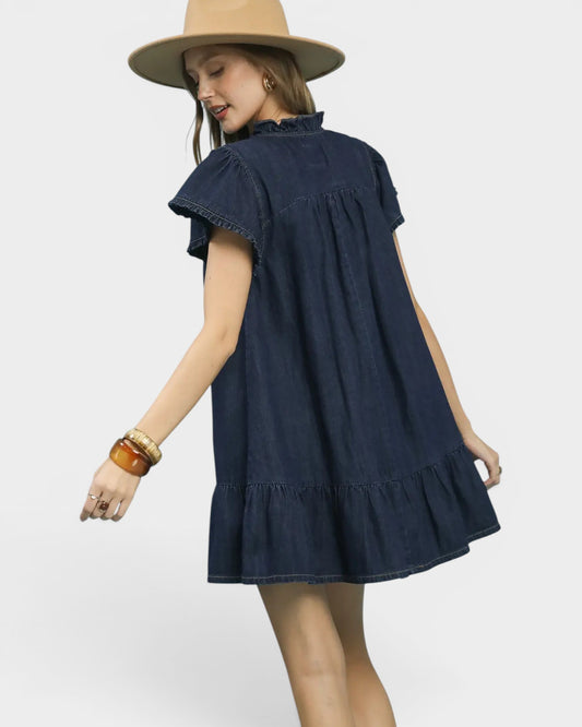 Woman wearing a navy blue dress and beige hat on a white background