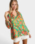 Woman wearing a colorful patterned blouse on a white background
