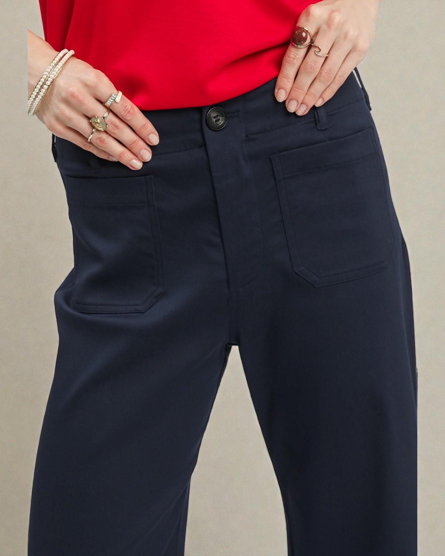 Navy pants worn with a red top on a neutral background