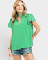 Woman wearing a green blouse with ruffled sleeves on a white background