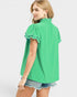 Woman wearing a green blouse with ruffled details on a white background