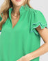 Green blouse with ruffled sleeves worn by a person on a white background